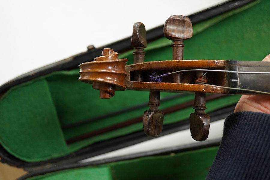 Four cased violins; an early 20th century violin, body 36cm, fitted with a microphone pick up taking a quarter inch jack plug, an early 20th century half size violin, body 32cm, and two student violins. Condition - poor